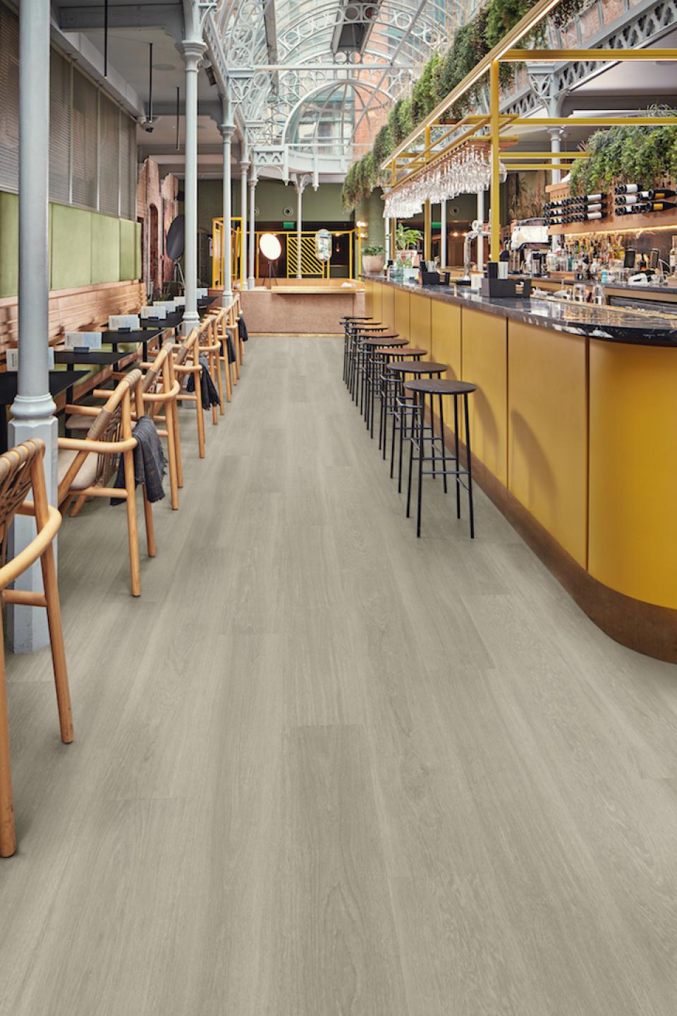 Interior view of a bar featuring Karndean's natural oak flooring, showcasing a modern design and vibrant atmosphere.