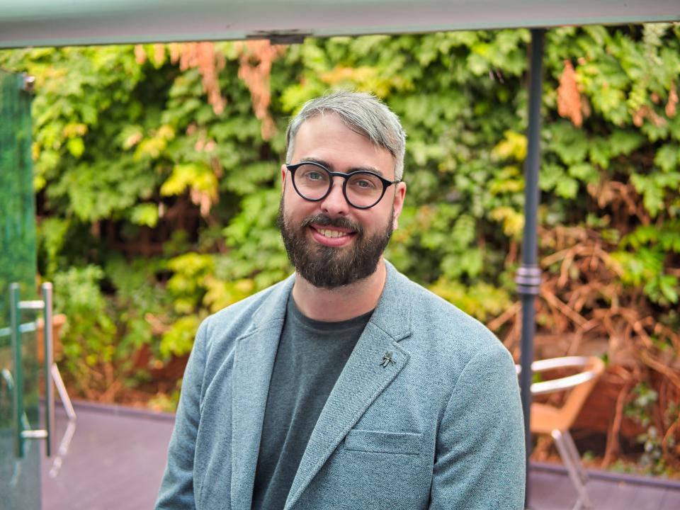 Matt Redding, associate at Gensler, smiling in front of greenery, reflecting on ESG principles for sustainable architecture.