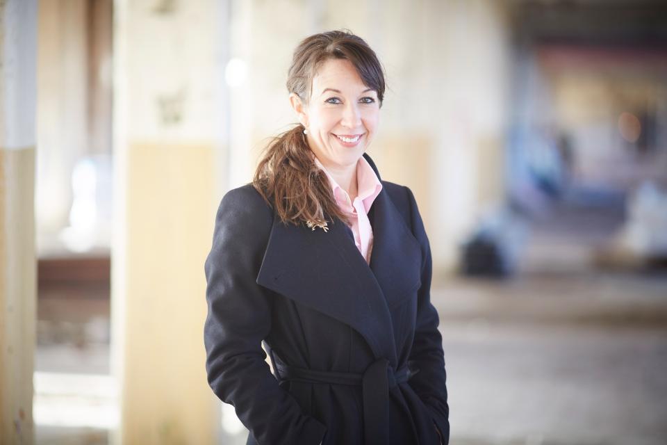 Georgina Lynch, MD, smiling in a heritage home setting, emphasizes sustainable retrofitting and carbon reduction in architecture.