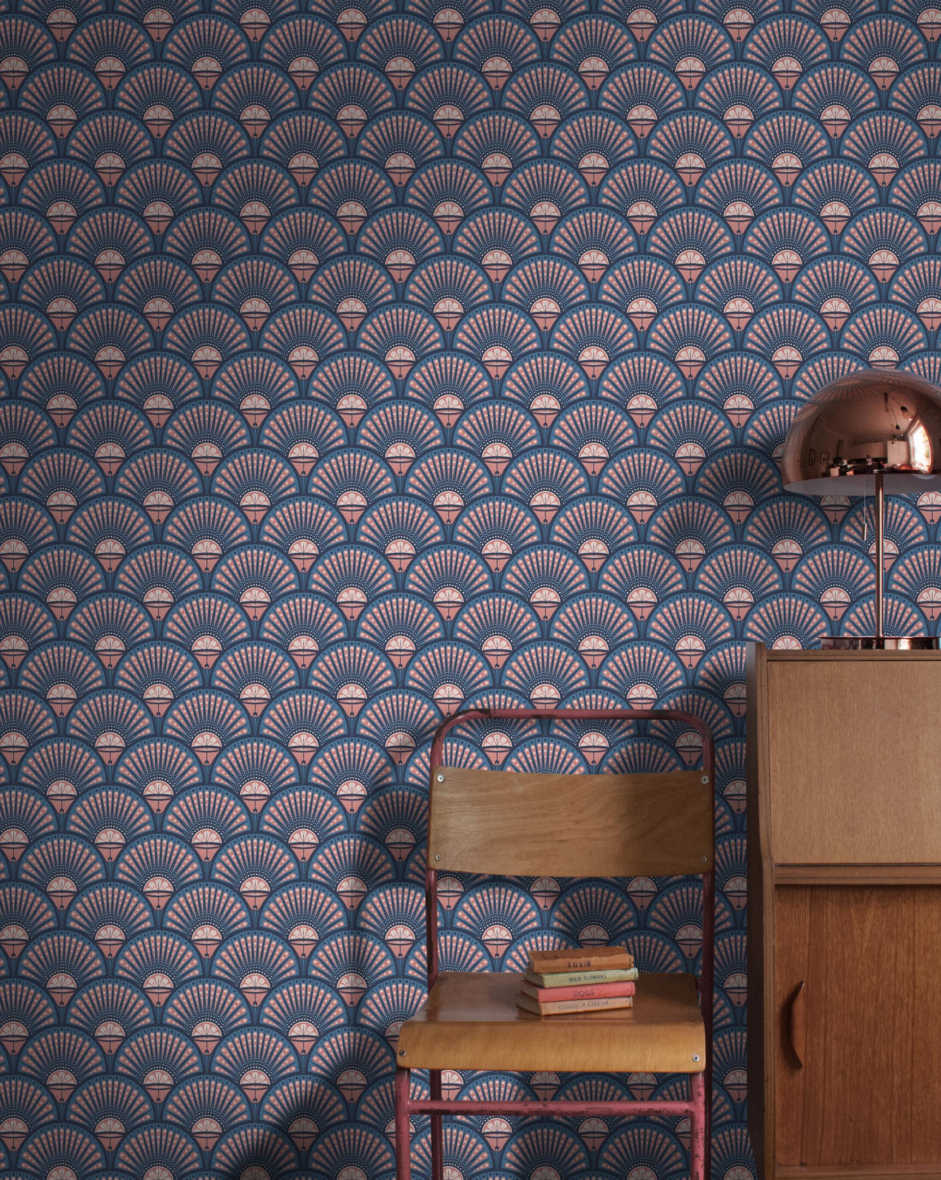 Elegant indoor scene featuring fan-patterned wallpaper, a wooden chair with stacked books, and a stylish lamp.
