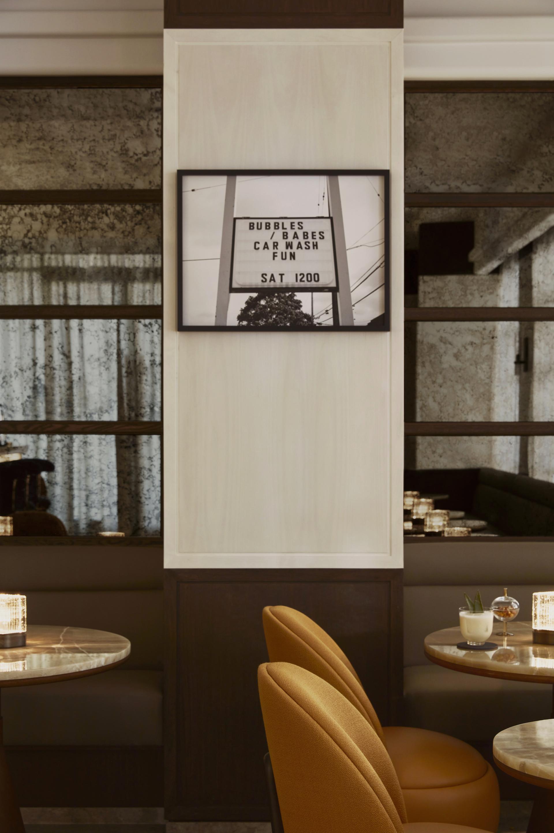 Antique-style sign in the Maybourne Bar announces "Bubbles / Babes Car Wash Fun" in a chic Art Deco setting.