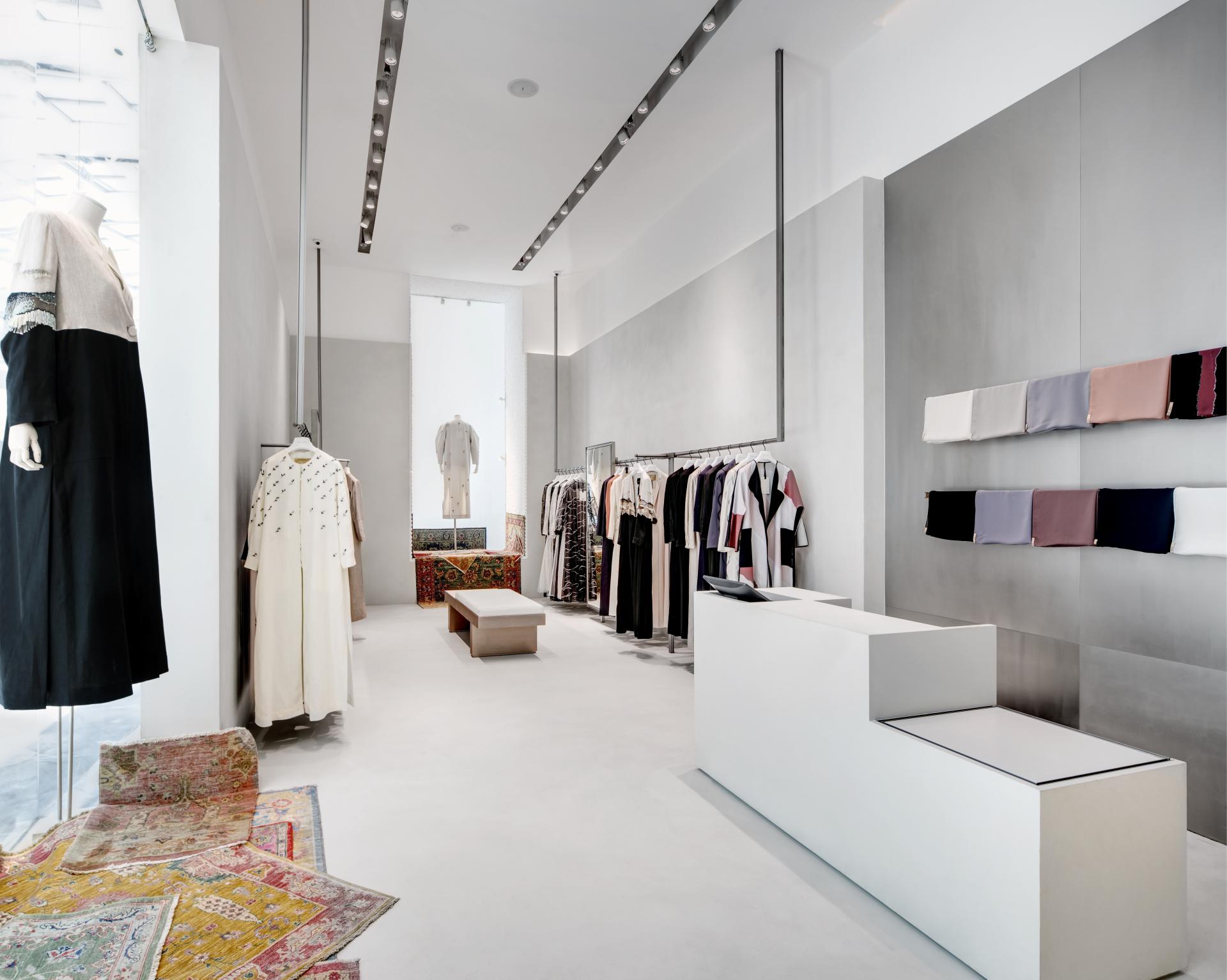 Stylish interior of THE KAPE store in Dubai, showcasing modest women's fashion garments and soft color palettes.