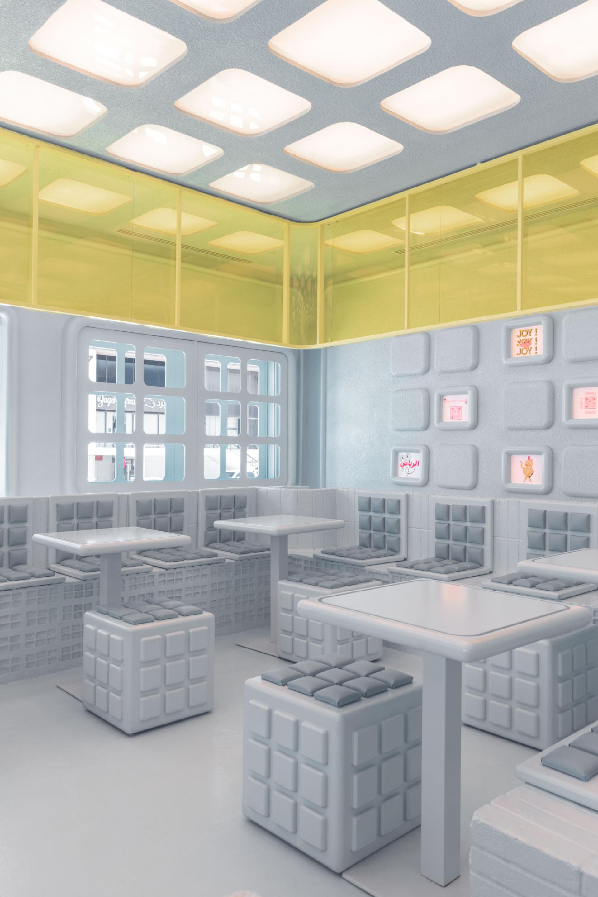 Futuristic interior design of Novu Waffle, featuring modular seating and vibrant colored walls by Masquespacio.