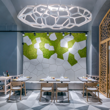 Contemporary dining area at Textúra restaurant, featuring parametric design elements, hexagonal wall patterns, and green moss accents.