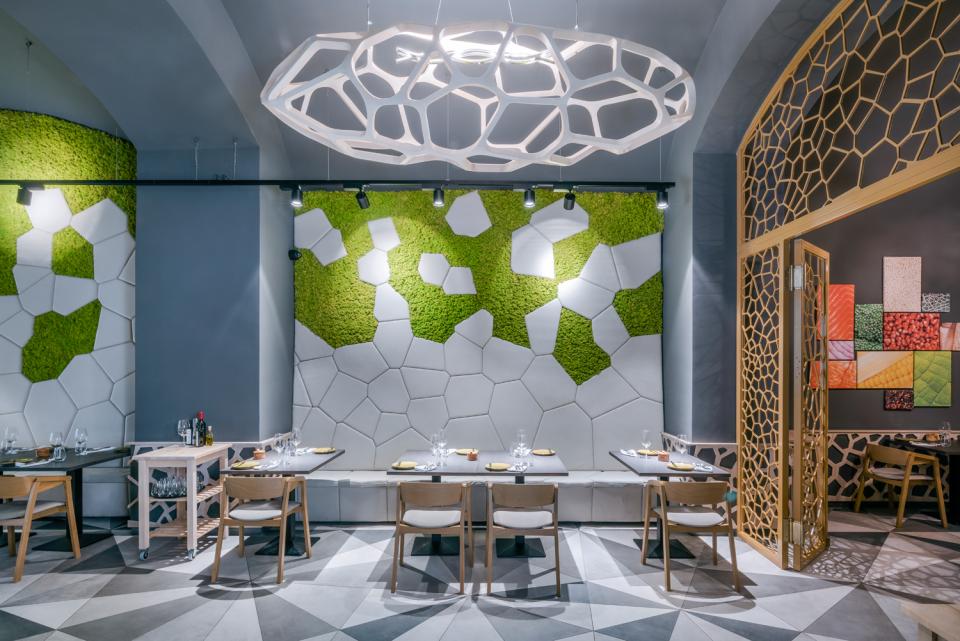 Contemporary dining area at Textúra restaurant, featuring parametric design elements, hexagonal wall patterns, and green moss accents.