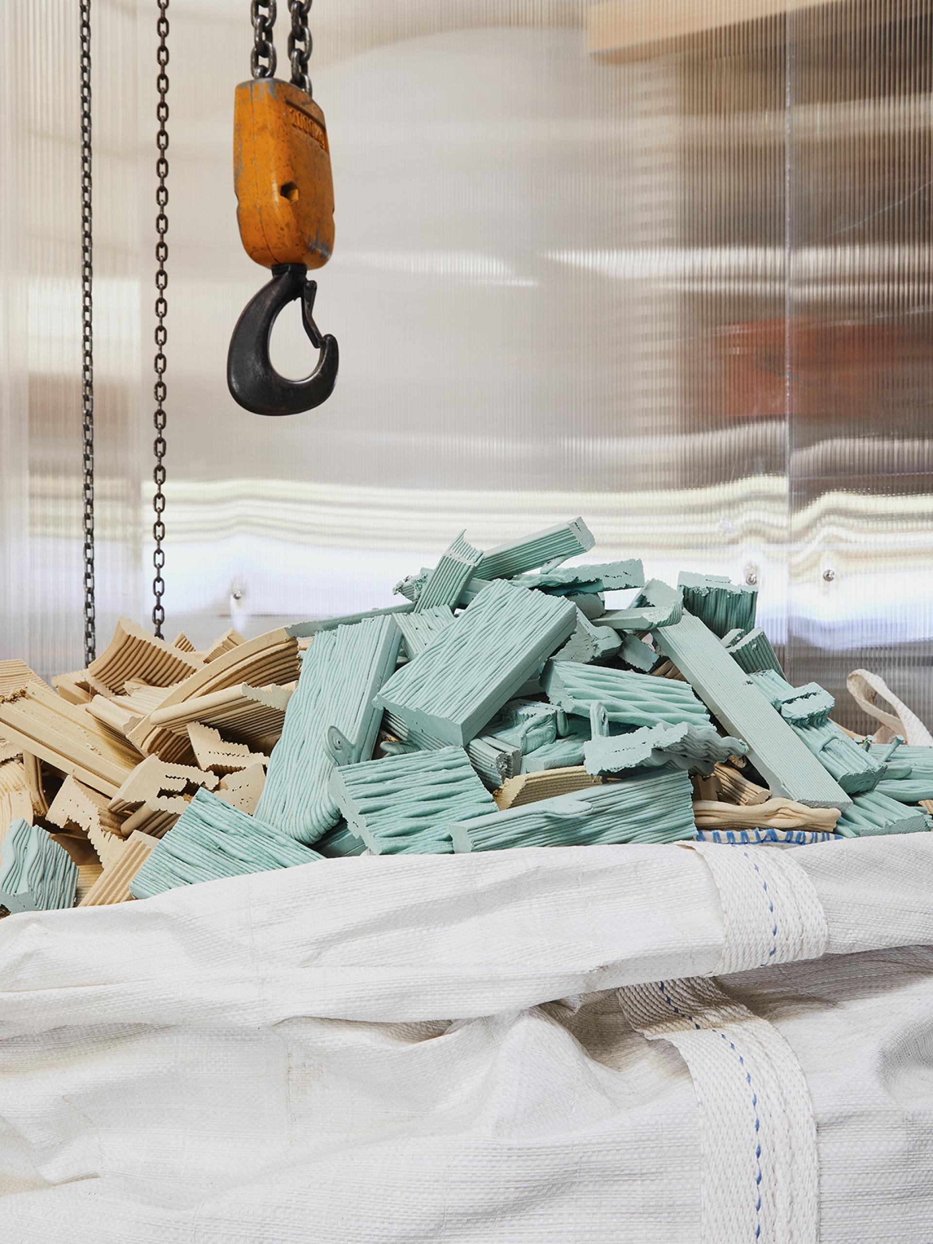 Colorful wooden scraps piled high in a white bag, highlighting sustainable materials for the Ermis chair by The New Raw.