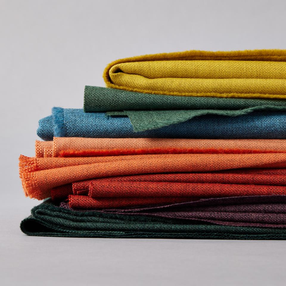 Wool Sumi fabric stack showcasing Camira's expanded color palette with vibrant hues including green, orange, and yellow.