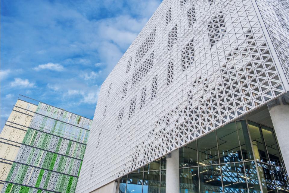Ventilated ceramic façade of Brighton University's Elm House, showcasing modern architecture against a clear blue sky.