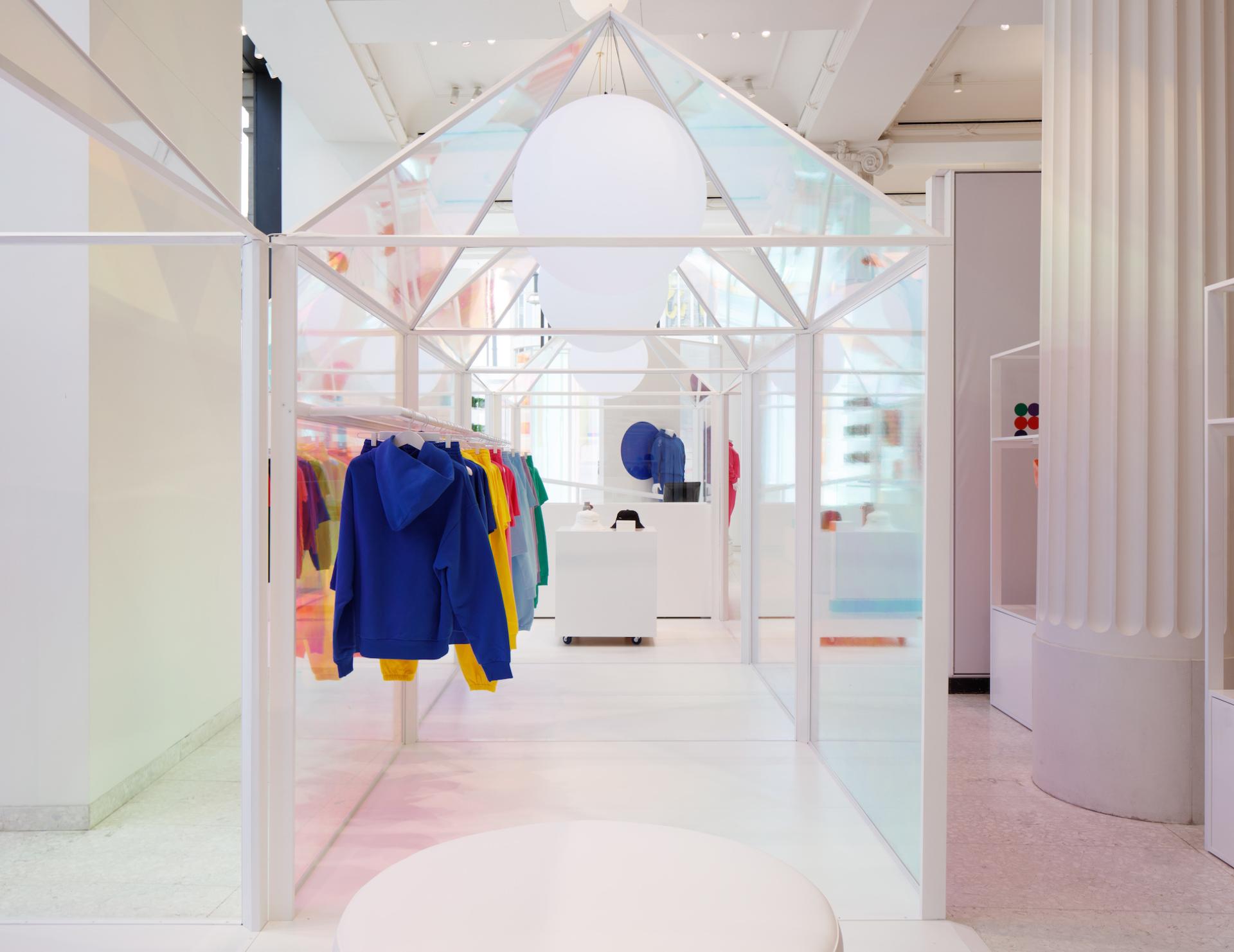 Colorful Pangaia clothing displayed in a playful pop-up store at Selfridges, featuring a modern, transparent design.