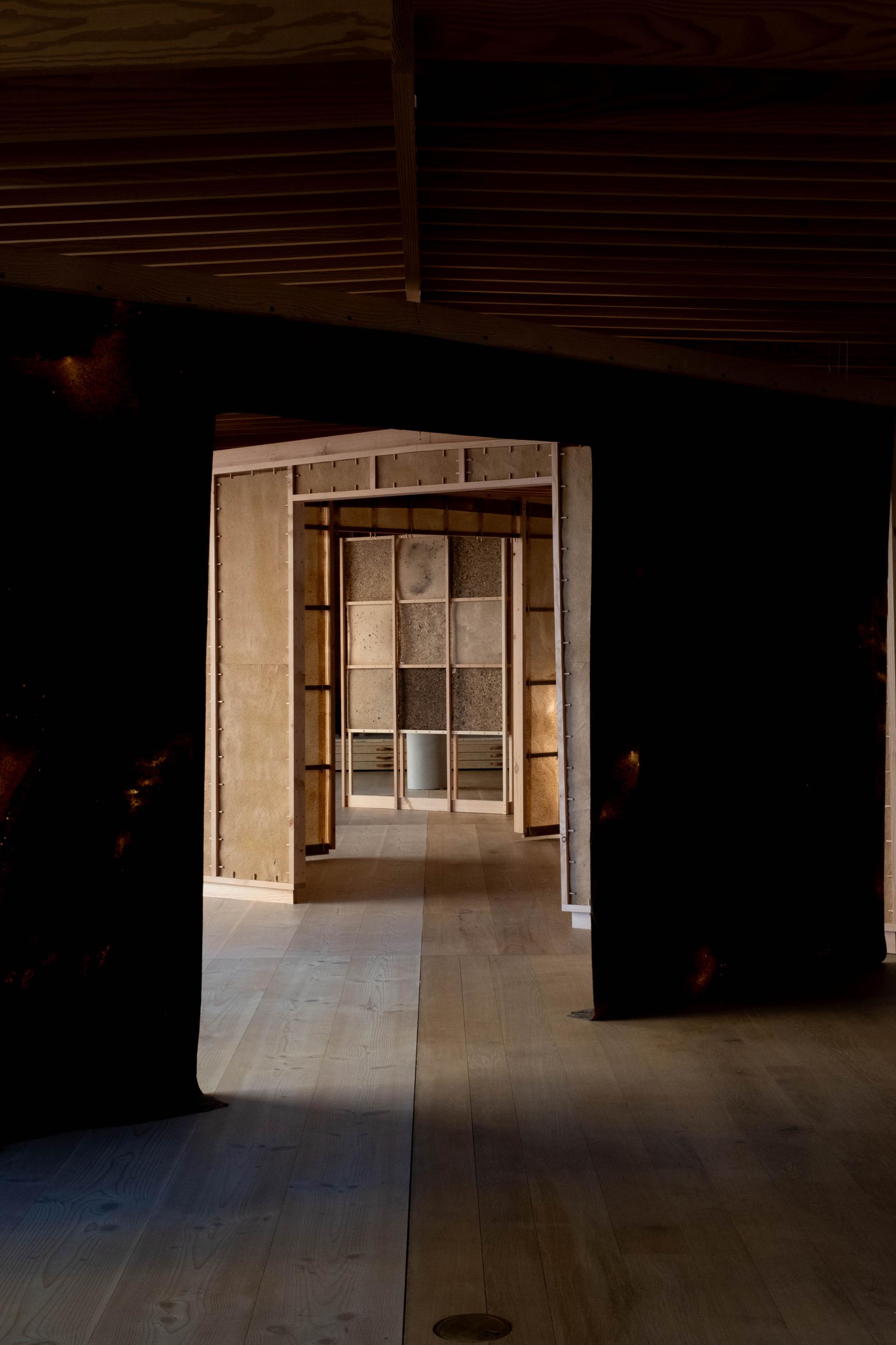 Architectural installation featuring wood and natural materials, showcasing textured panels and spacious design by SMULD.