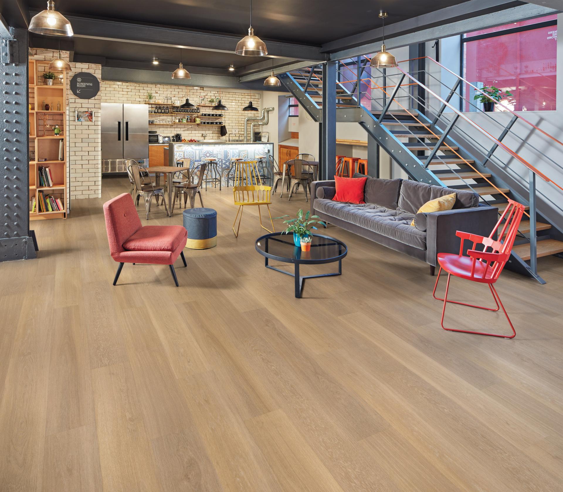 Stylish modern workspace with mixed seating, cozy lounge area, and a communal kitchen, promoting workplace hospitality design.