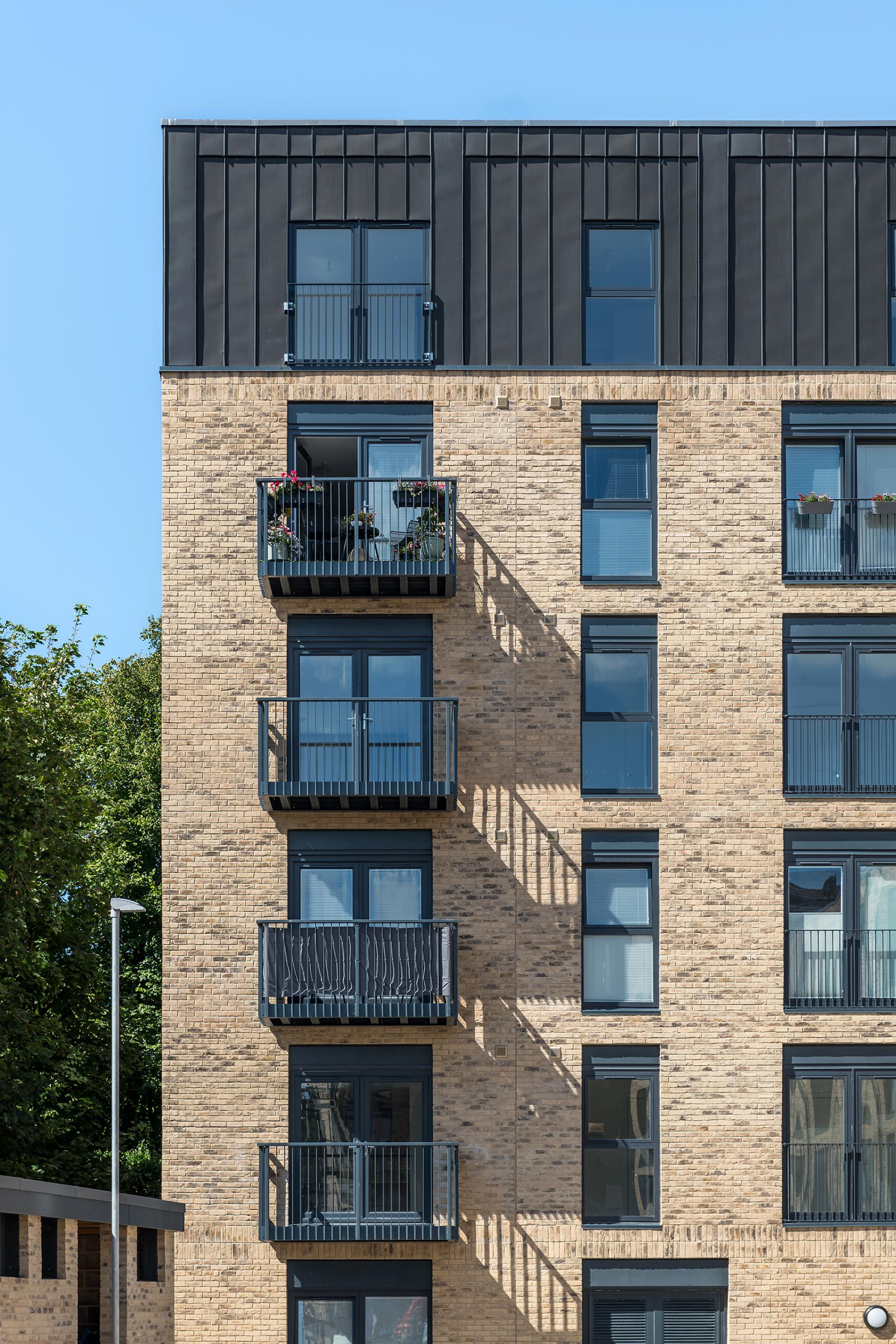 Modern residential building facade featuring multiple balconies, emphasizing Scotland's need for better housing solutions.
