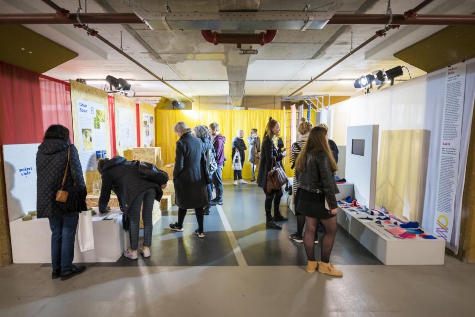 Visitors explore innovative designs at Dutch Design Week, showcasing sustainable projects and creative concepts in a vibrant exhibit.