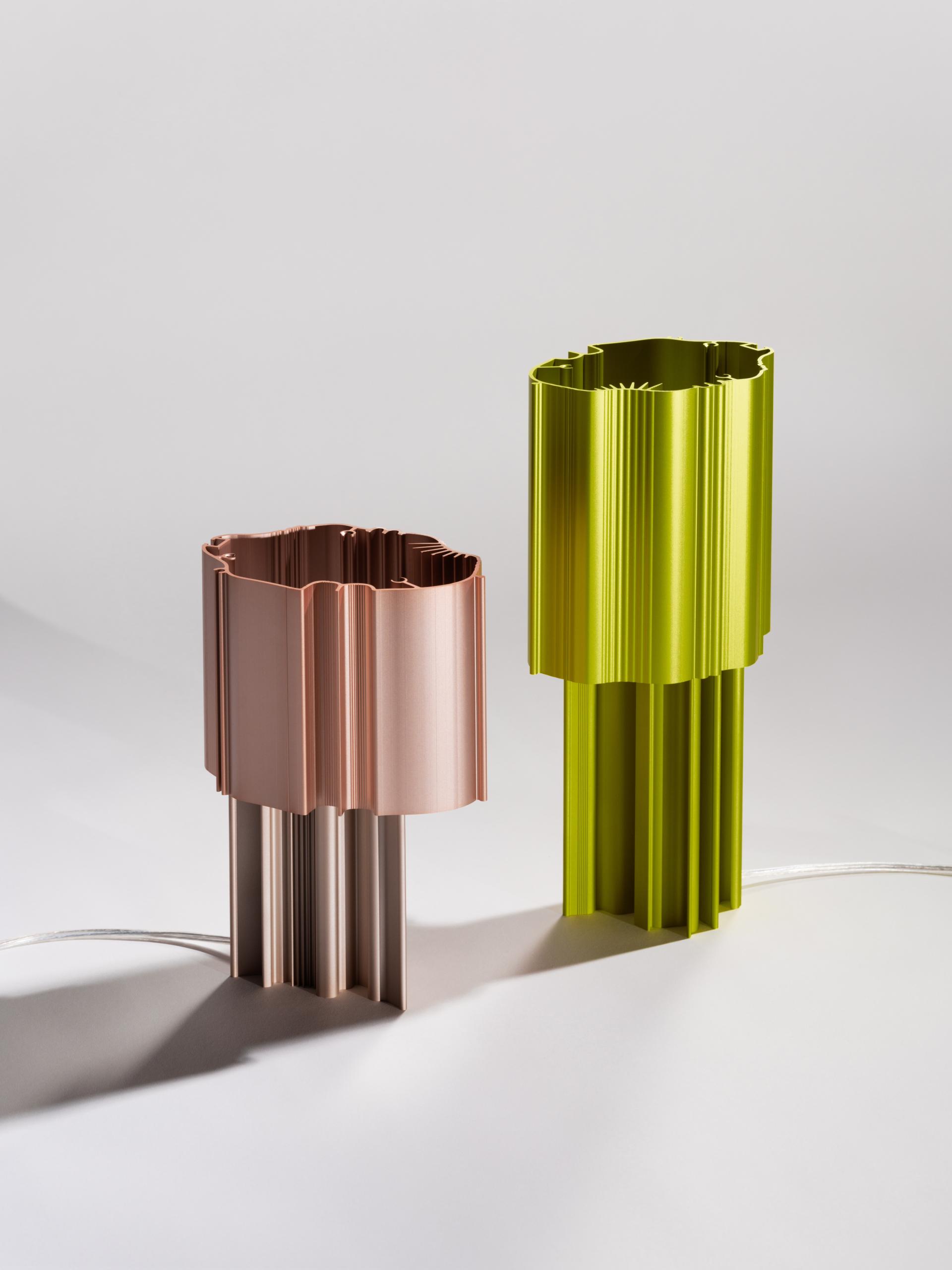 Two modern lamps crafted from recycled materials, showcasing vibrant pink and green colors, emphasizing sustainable design at the Material Matters Fair.