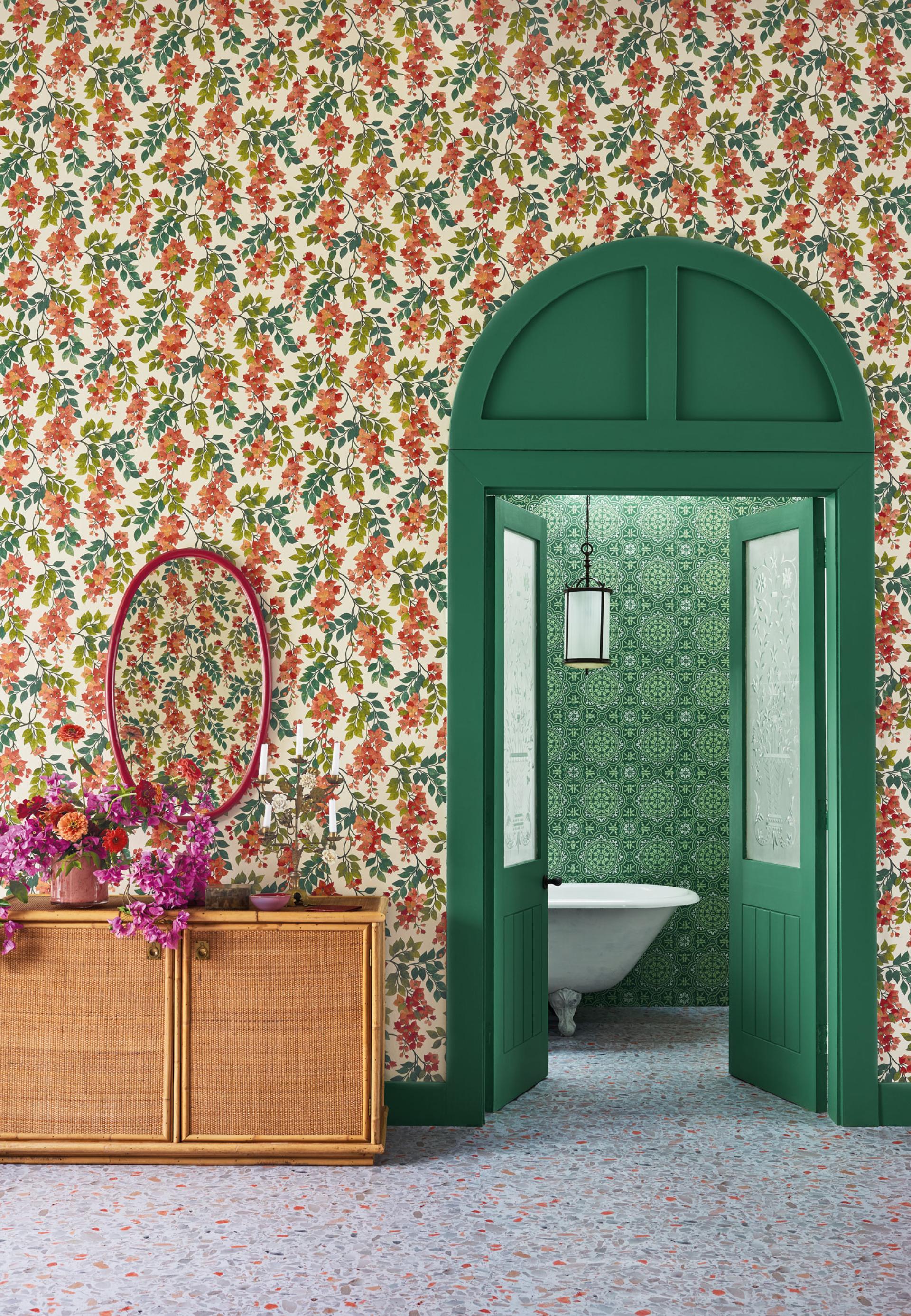 Vibrant room featuring floral wallpaper, green doors, a vintage sink, and a decorative wooden cabinet with flowers.