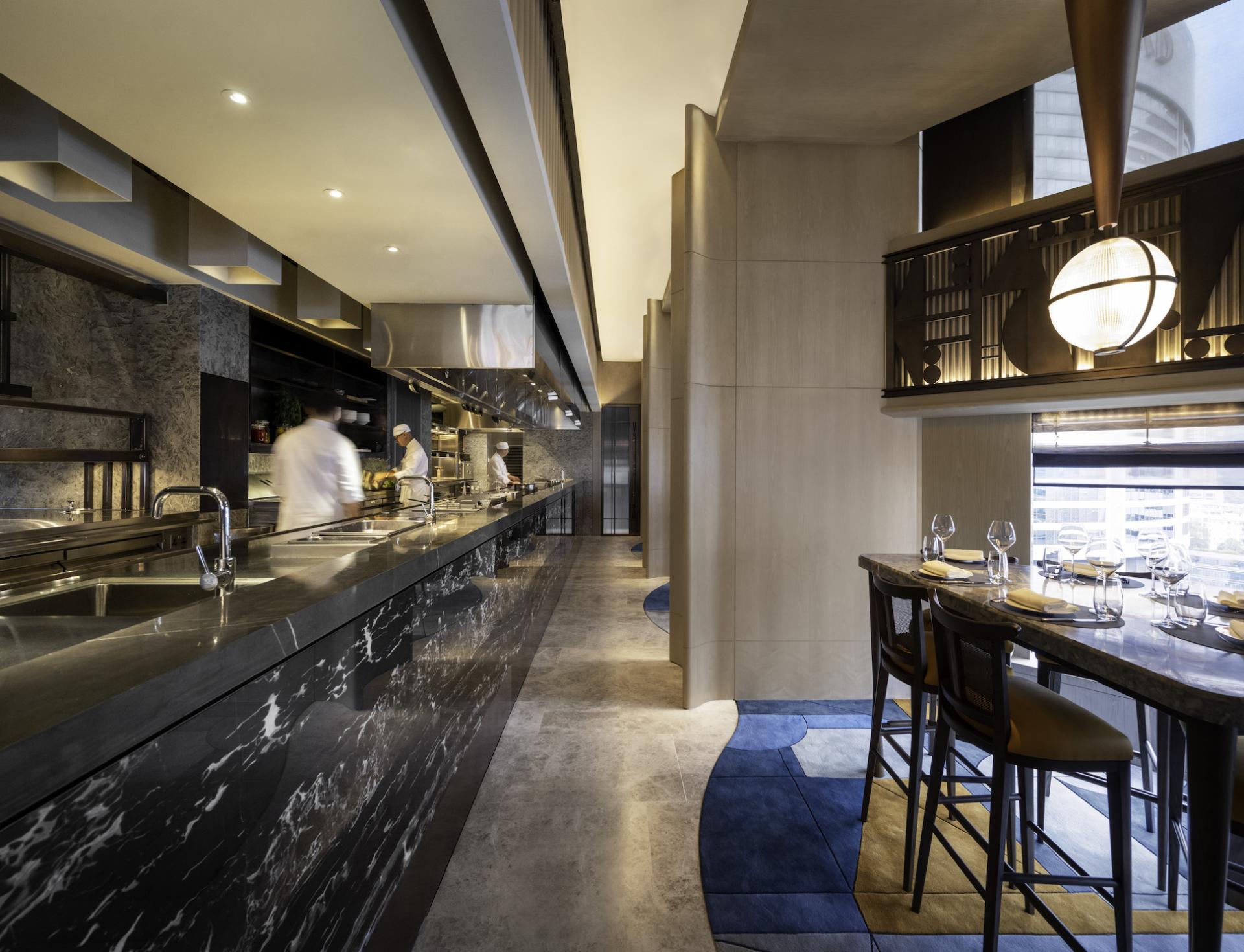 Modern Art Deco-inspired restaurant interior at The Upper House, featuring a sleek kitchen and elegant dining area.