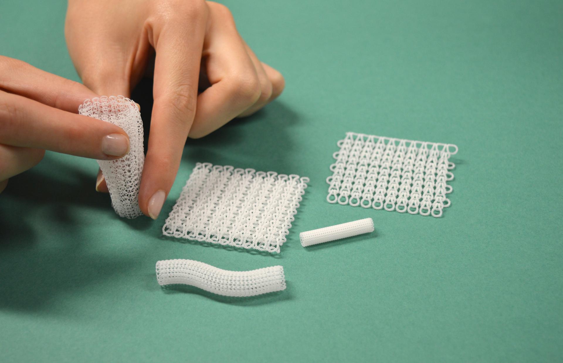 Hands manipulating various white 3D printed objects, showcasing innovative designs and applications in 3D printing technology.