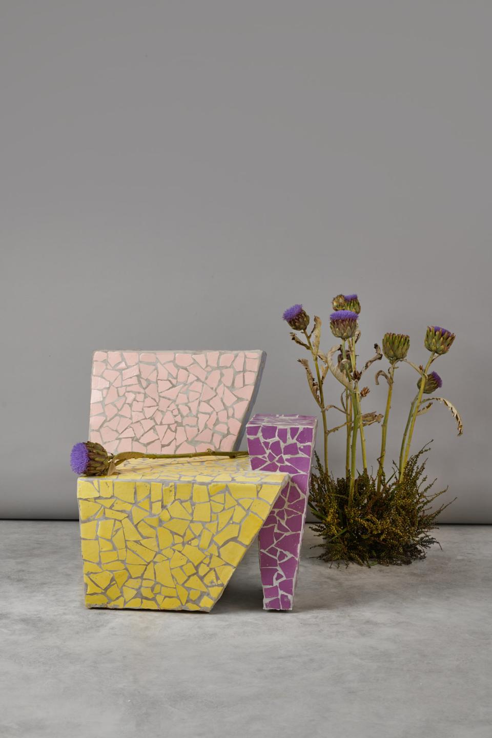 Colorful mosaic chair designs from the 3 Characters collection by Masquespacio, accompanied by dried flowers.