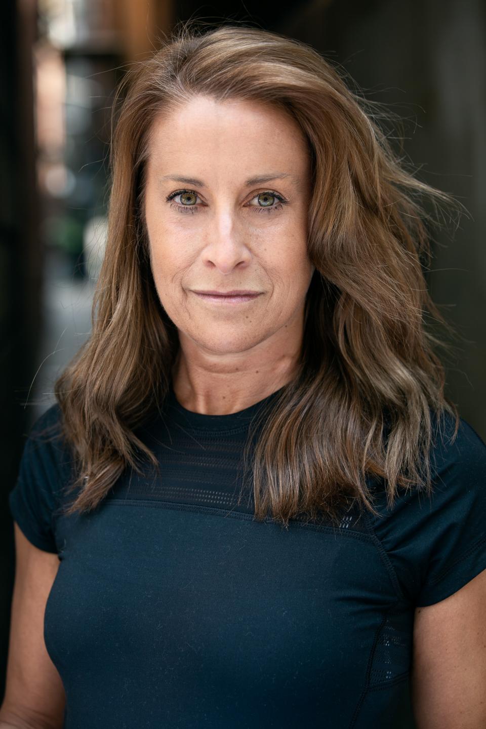 Award-winning British designer Nicola Schellander poses confidently, showcasing her passion for craftsmanship and the crystal industry.