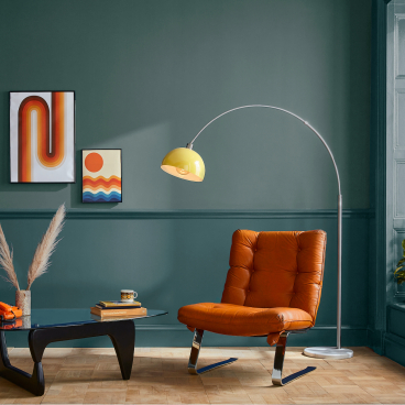 Stylish living room featuring a trendy orange chair, modern art, and vibrant decor in a curated color palette.