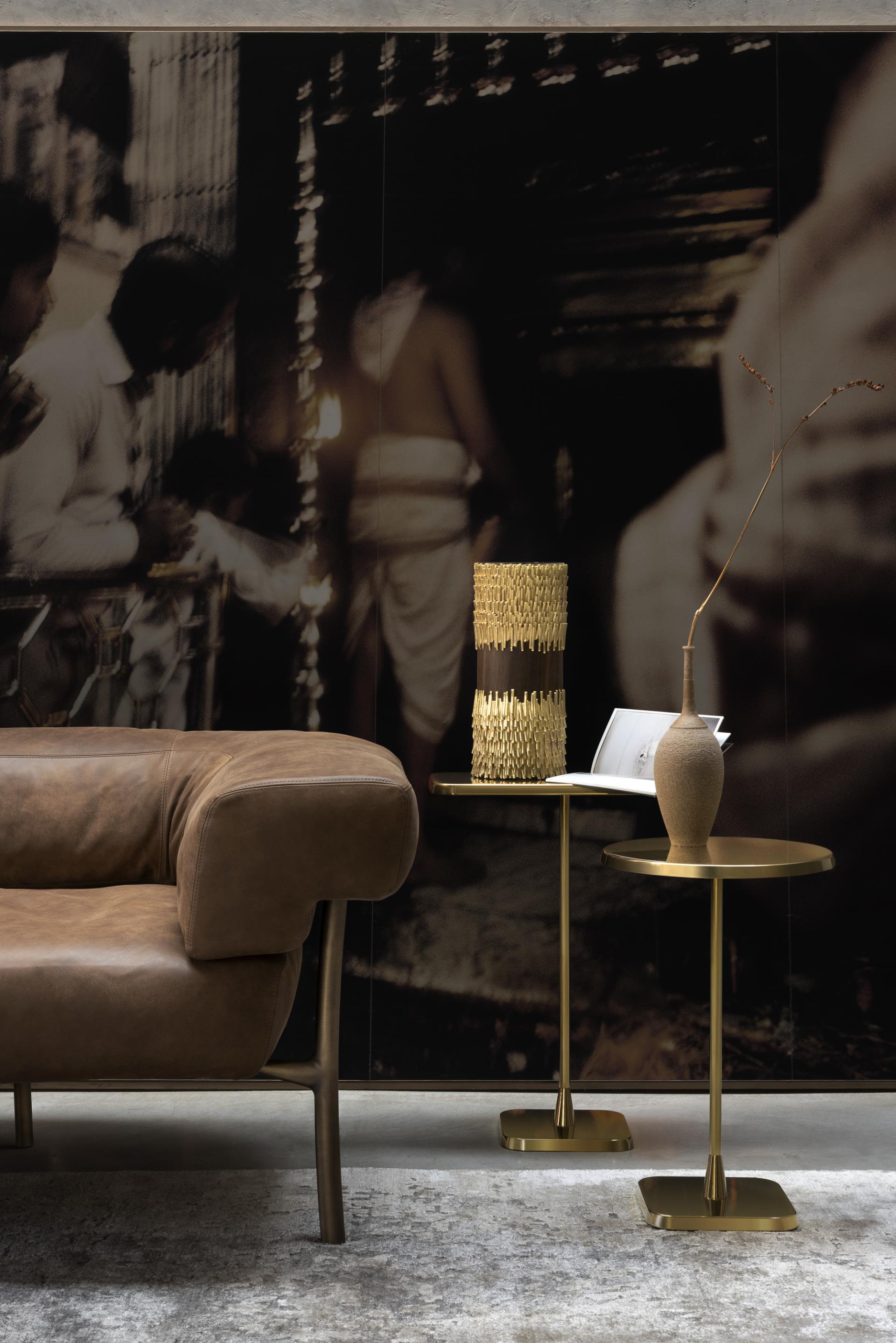 Elegant interior featuring GHIDINI 1961 brass design elements, showcasing a modern couch, stylish tables, and decorative vases.