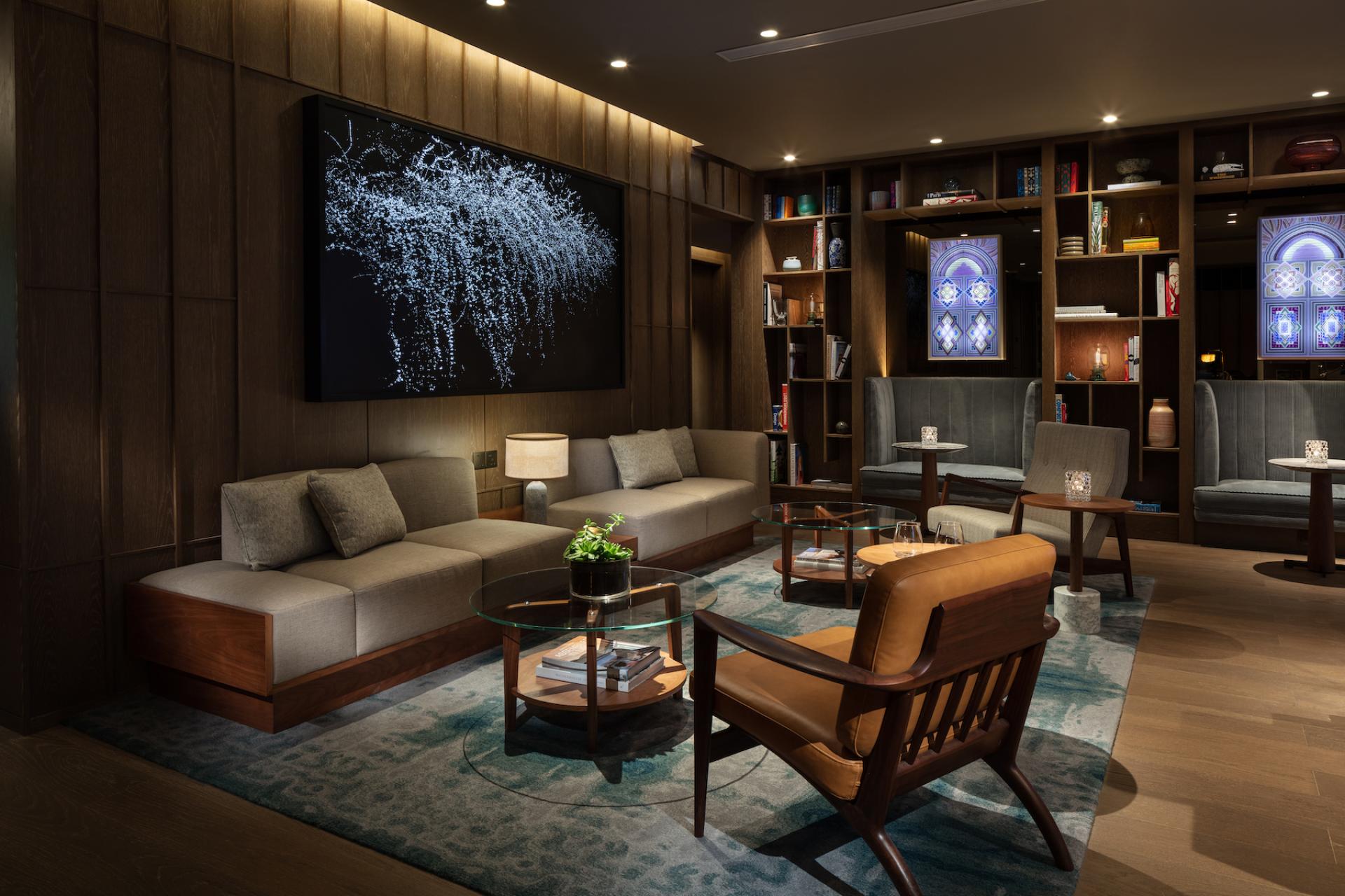 Sophisticated lounge area at The Hari Hong Kong featuring modern furniture, vibrant decor, and ambient lighting.