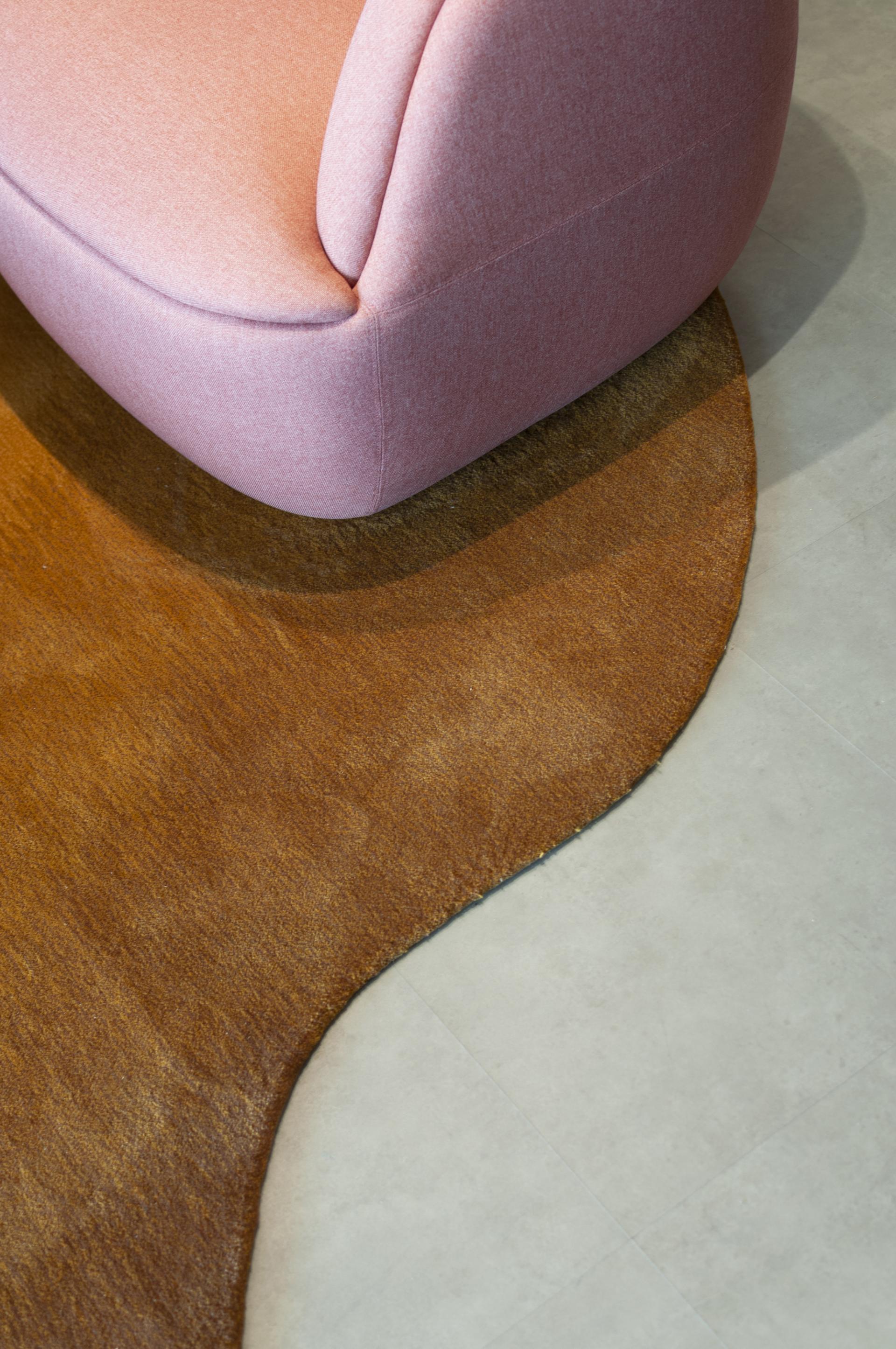 Stylish pink sofa on a textured brown rug in Warner Music Hong Kong's contemporary office design by Bean Buro.