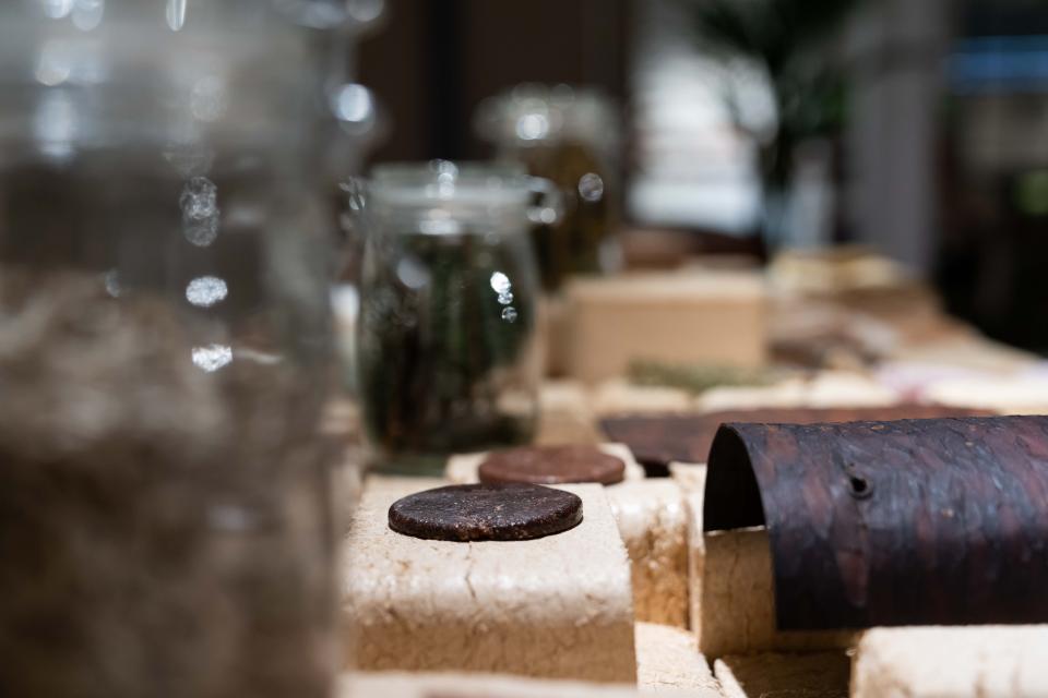 Display of various biomaterials, including jars and organic textures, showcased in the "From The Ground Up" exhibition.