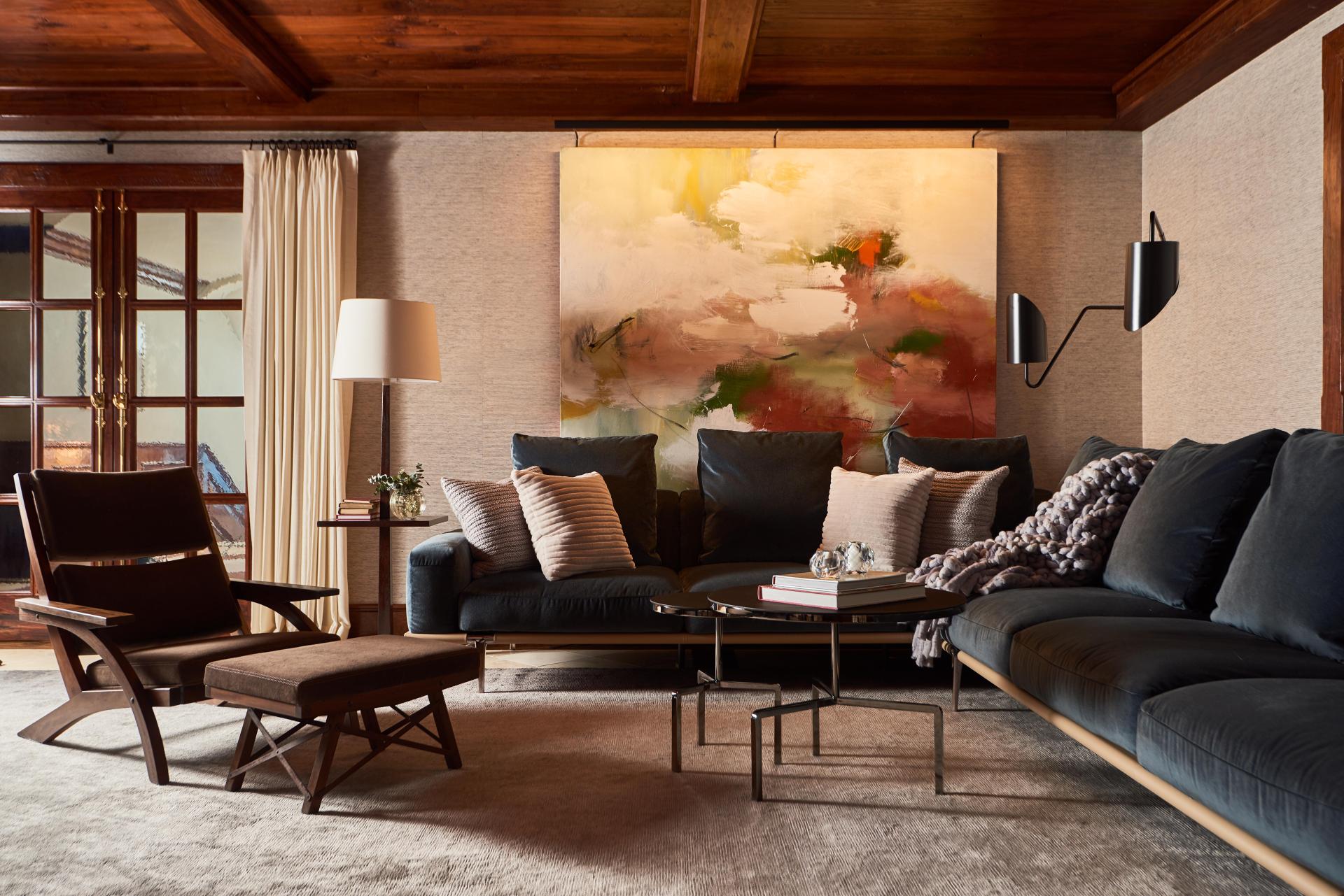 Elegant ski chalet living room featuring a cozy sectional, artistic wall decor, and textured furnishings by Champalimaud Design.