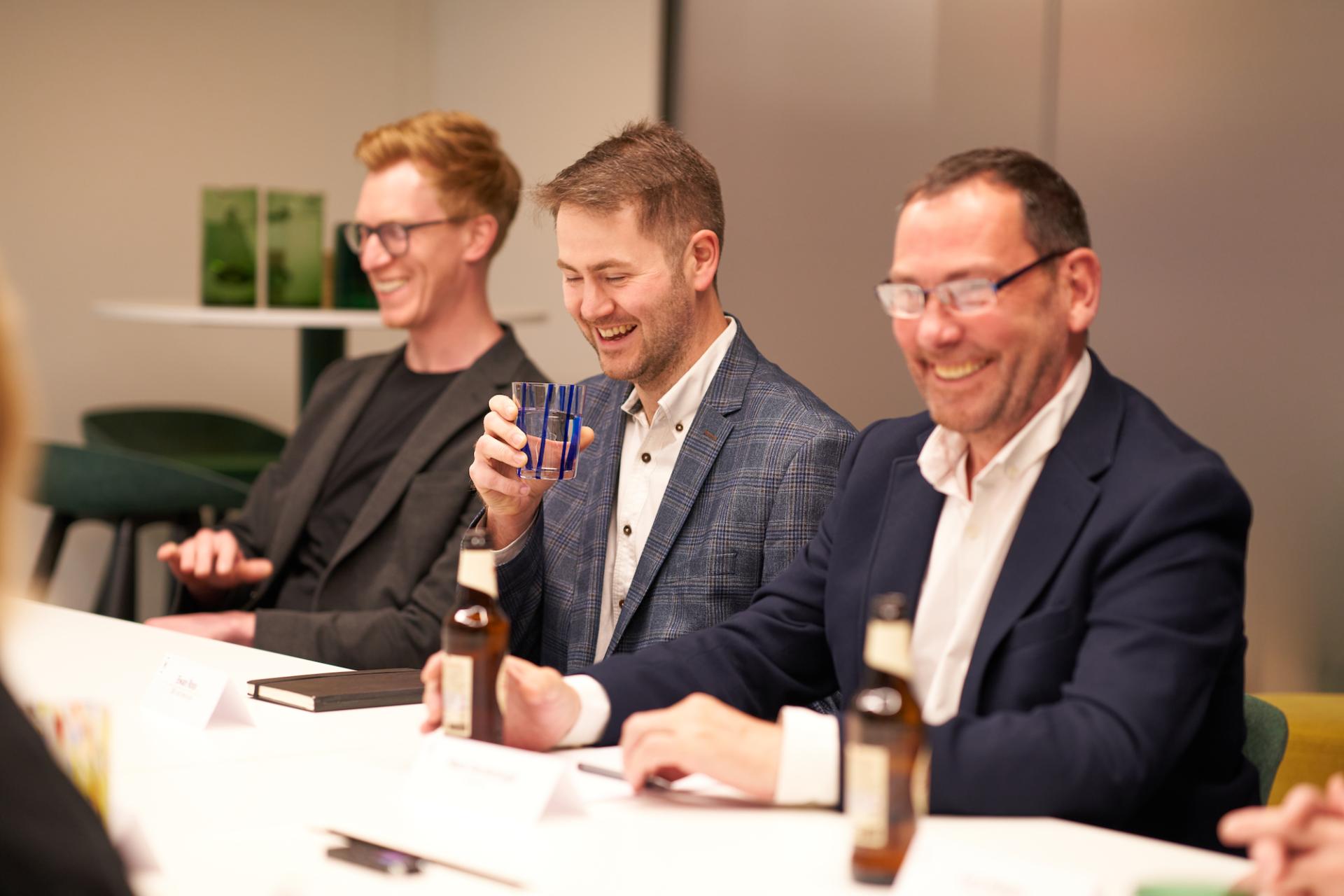 Professionals engaged in discussion at a Material Source Studio event, examining Glasgow's residential property landscape.