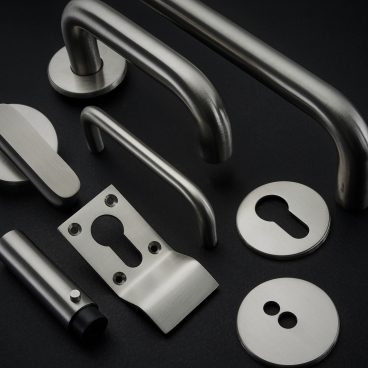 Antimicrobial copper alloy architectural hardware pieces from Allgood's Contego collection displayed on a dark background.