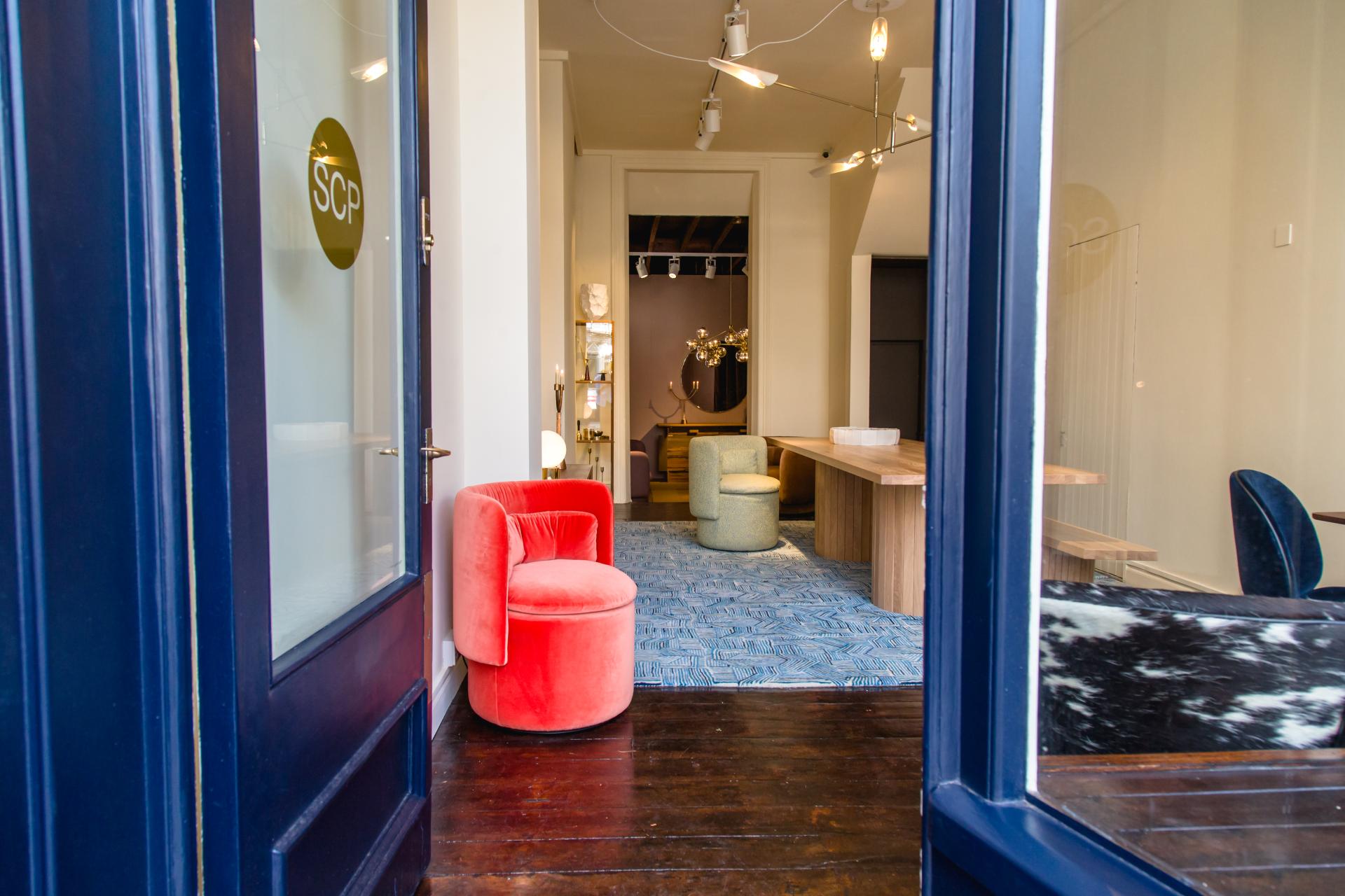 Colorful furniture and wooden table showcased in SCP's new showroom on Pimlico Road, central to Grosvenor Estate.