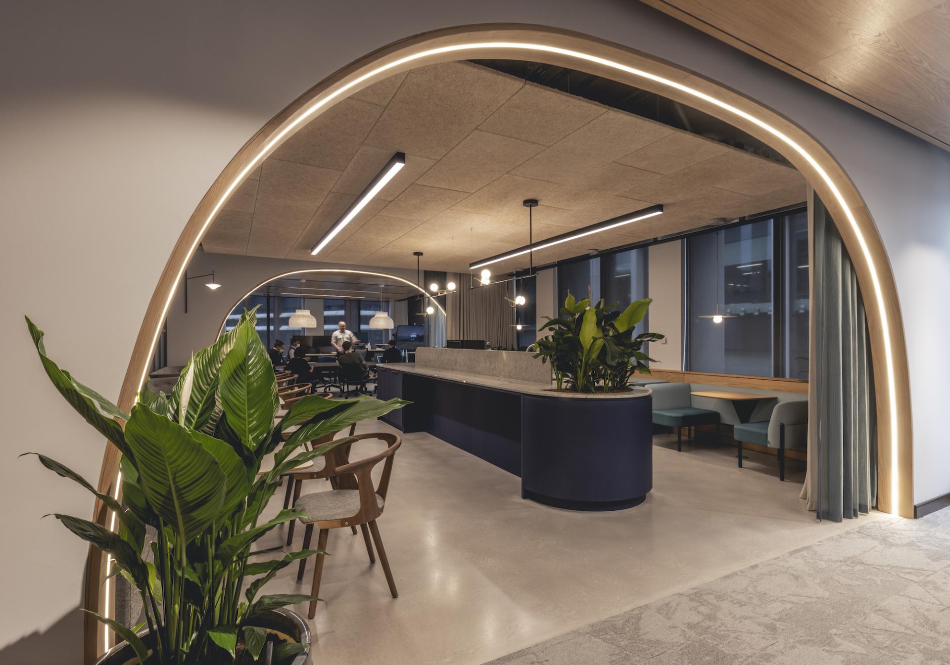 Modern workspace design featuring stylish seating, a curved reception area, lush plants, and large windows at AstraZeneca UK.