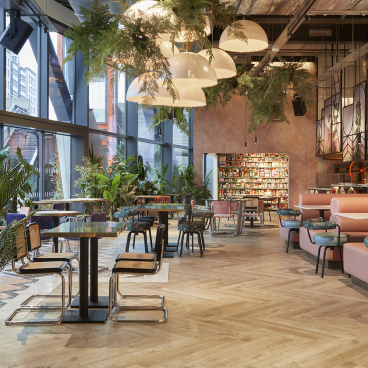 Stylish interior of Bondi Green featuring vibrant decor, greenery, and cozy seating in a Miami-inspired dining venue.