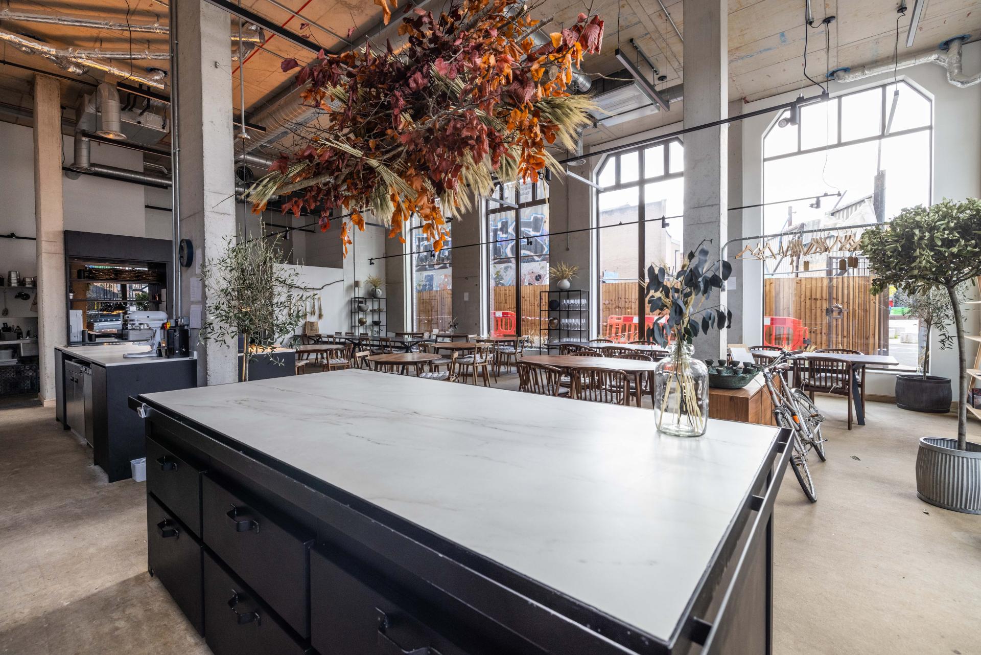 Stylish interior of The Water House Project restaurant featuring Dekton surfaces, elegant decor, and natural light.
