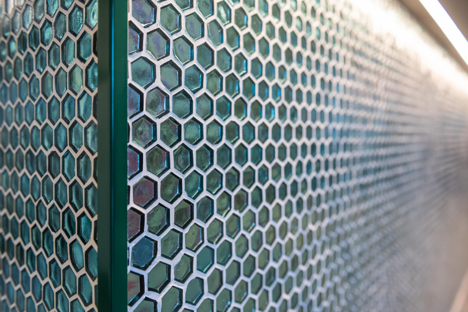 Textured hexagonal tiles in shades of teal and white create a modern, sophisticated design element in H2R's Rove Bar.