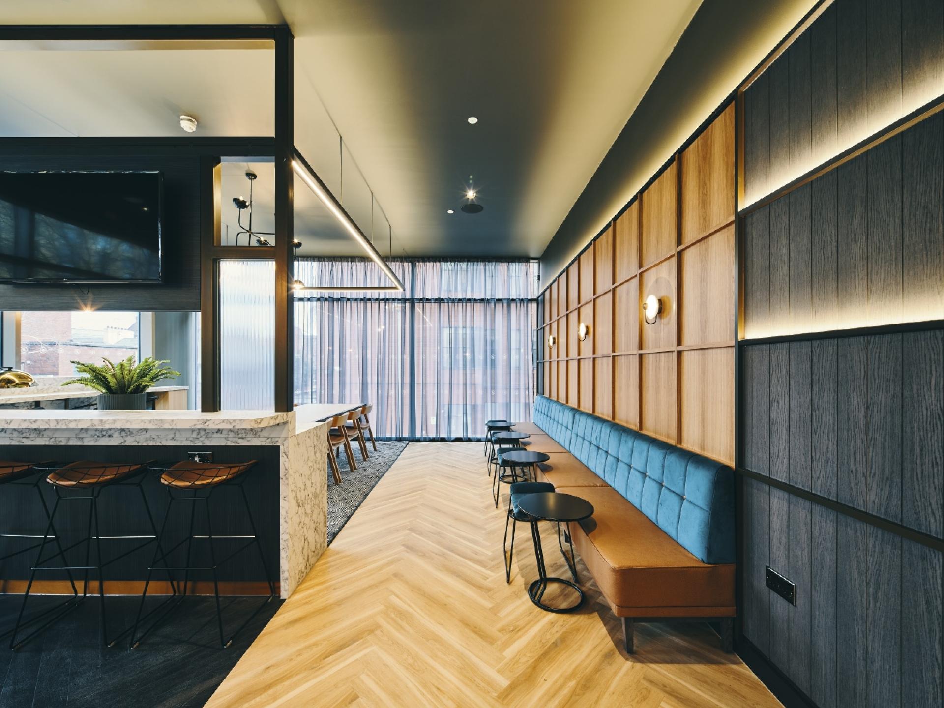 Modern interior design featuring a sleek bar, stylish seating, and layered materials at 74 in Manchester.
