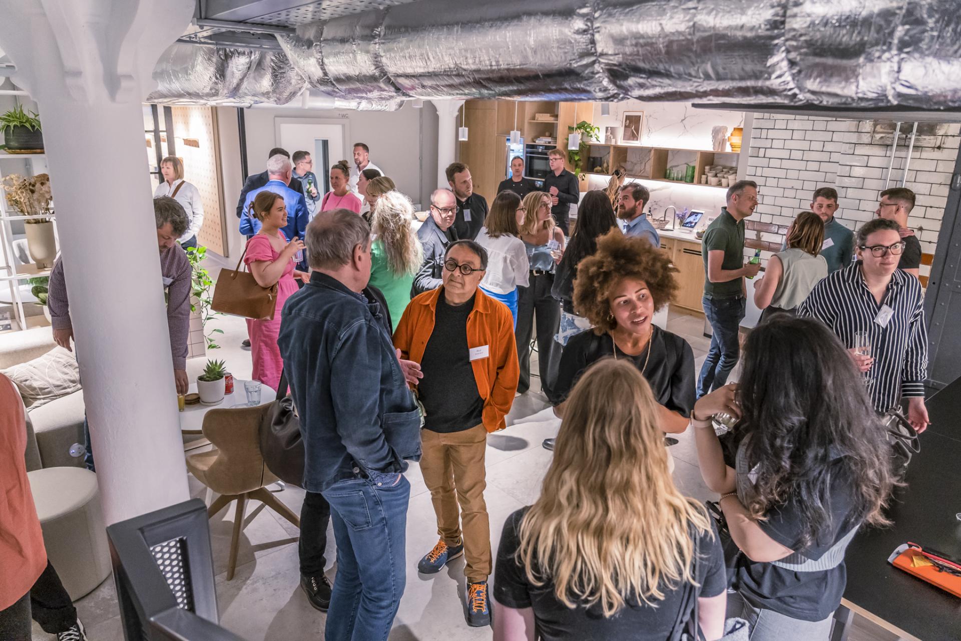 Networking event showcasing diverse professionals discussing the Future of the Workplace in a modern, collaborative space.