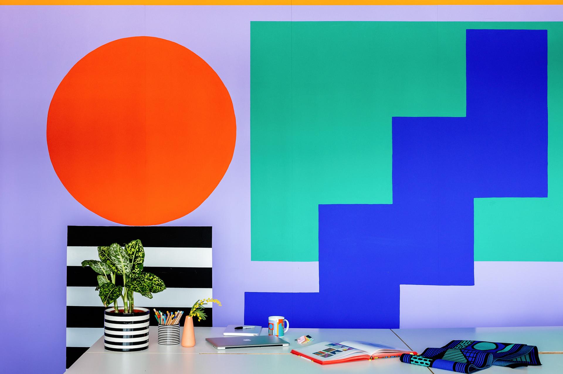 Vibrant studio interior showcasing Camille Walala's geometric mural, colorful decor, and artistic workspace elements.