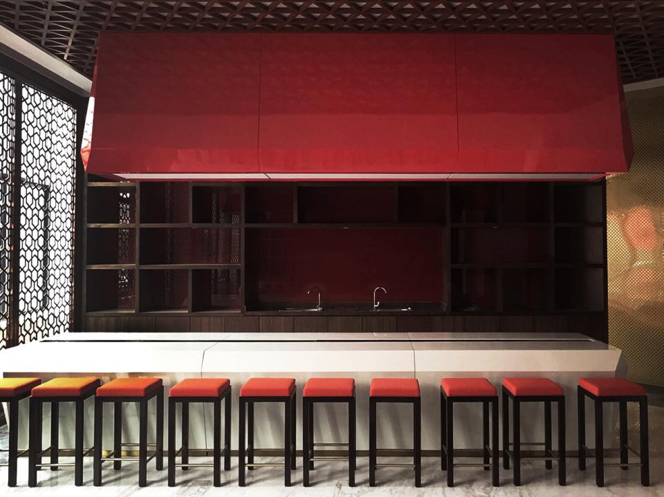 Modern bar area with red accents and orange stools, highlighting SenseLab's sensory experience design for a Chinese liquor factory.