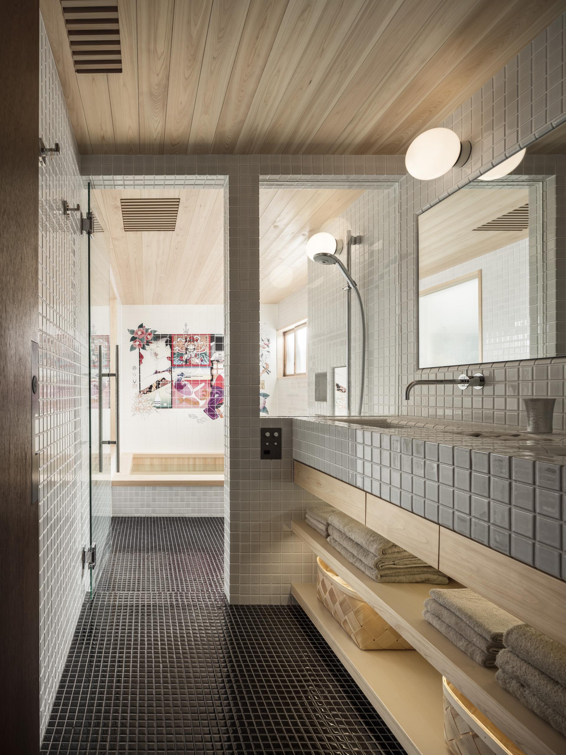 Modern bathroom design featuring sleek tiles, wooden accents, and a minimalist aesthetic at TRUNK(HOUSE) in Tokyo.