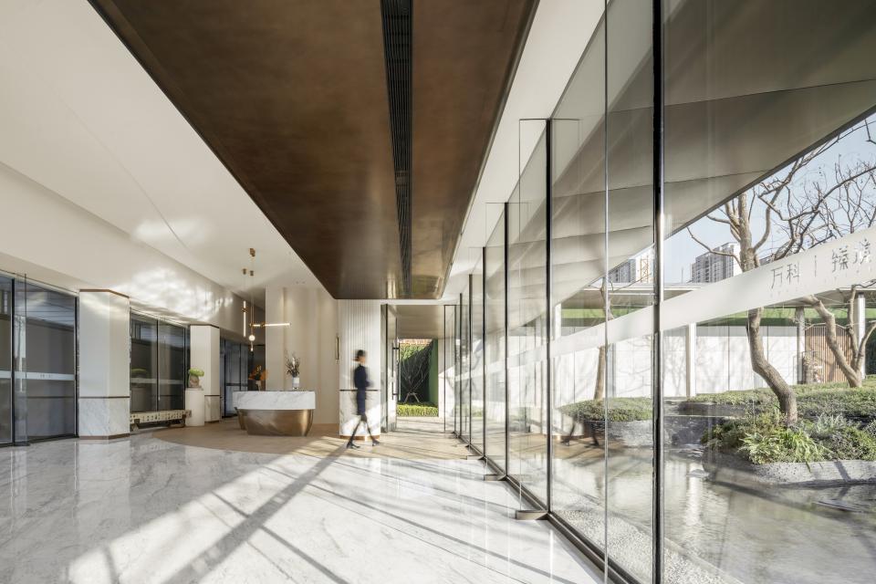 Elegant interior of a coffee space designed by Karv One, showcasing marble floors and large glass windows.