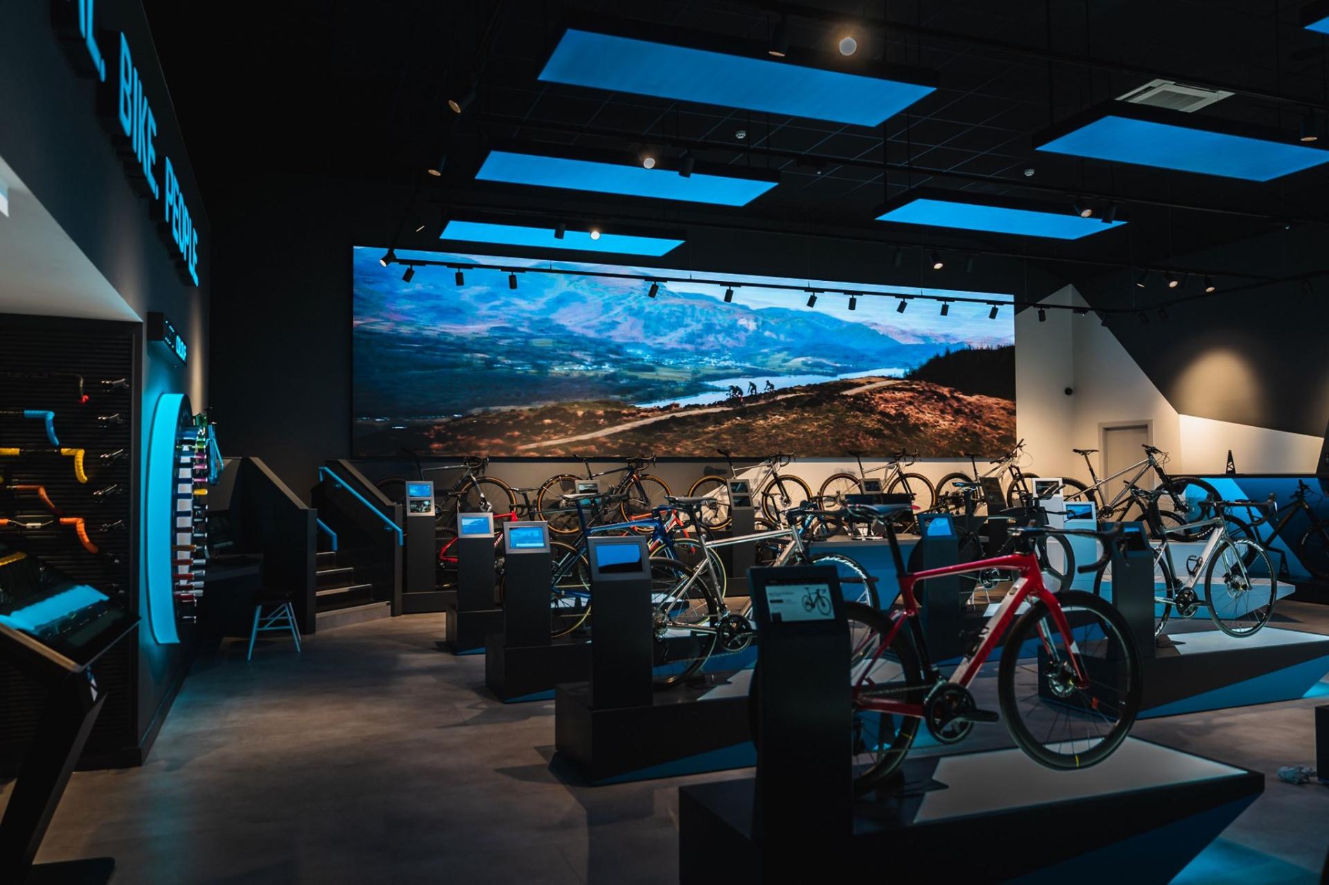 Modern bike showroom featuring various bicycles and a scenic backdrop, highlighting the upcoming Material Source Studio launch.