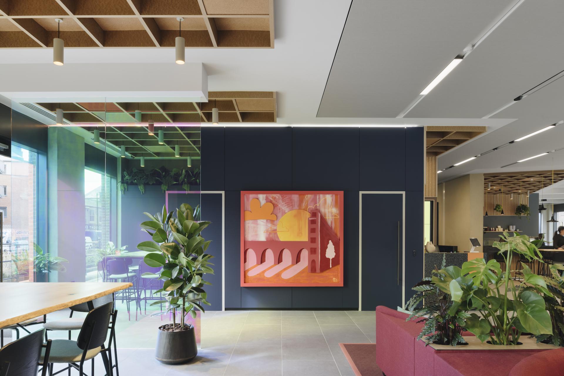 Modern interior design at Globe Point, featuring vibrant artwork, greenery, and a blend of industrial and digital elements.