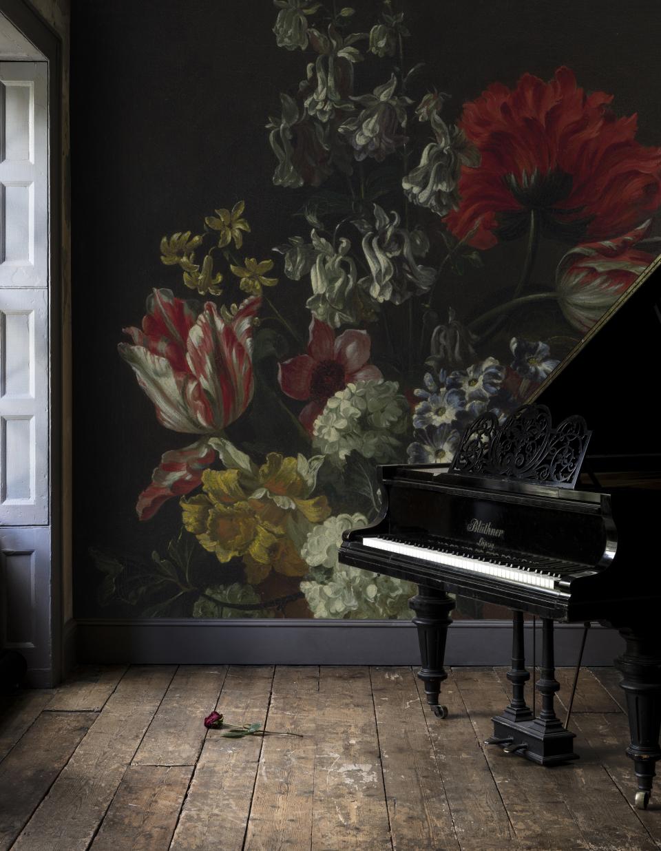 Luxurious black piano beside a wall adorned with dark, dramatic floral prints, featuring tulips, poppies, and roses.