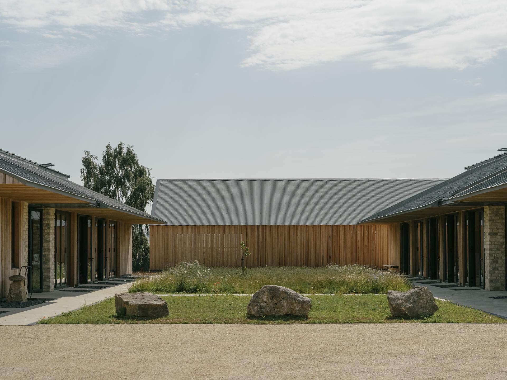 Sustainable farming education centre in the Cotswolds, featuring natural materials and surrounded by vibrant landscapes.