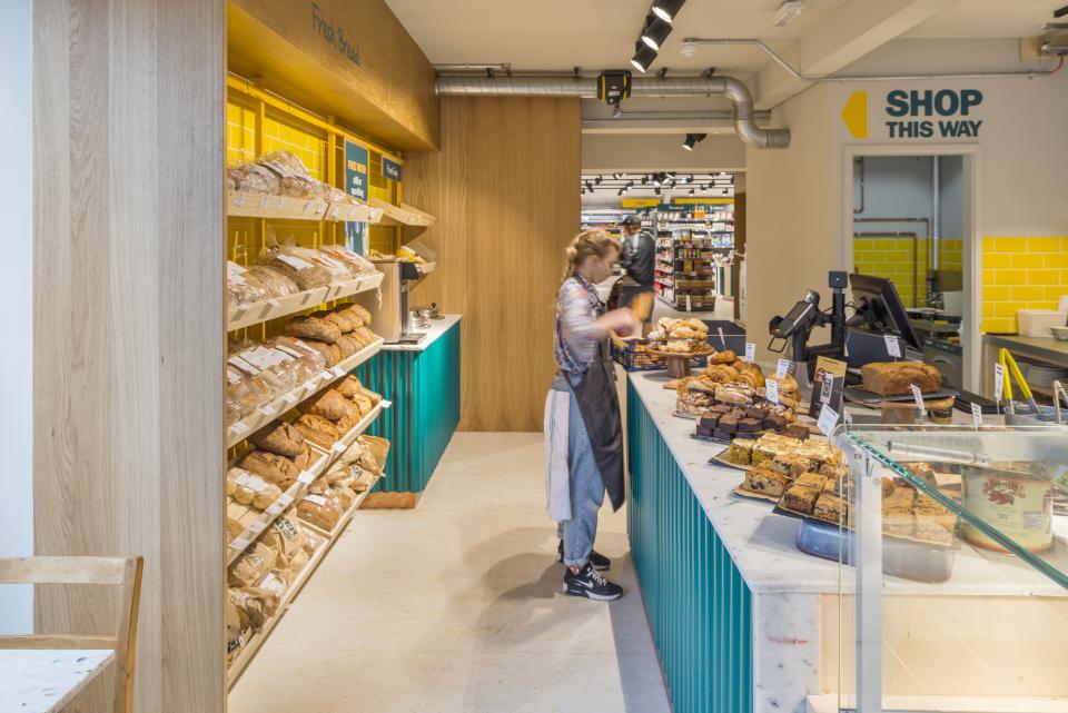 Brightly designed café-deli featuring fresh bread and baked goods, showcasing Better Food's new Gloucester Road store layout.