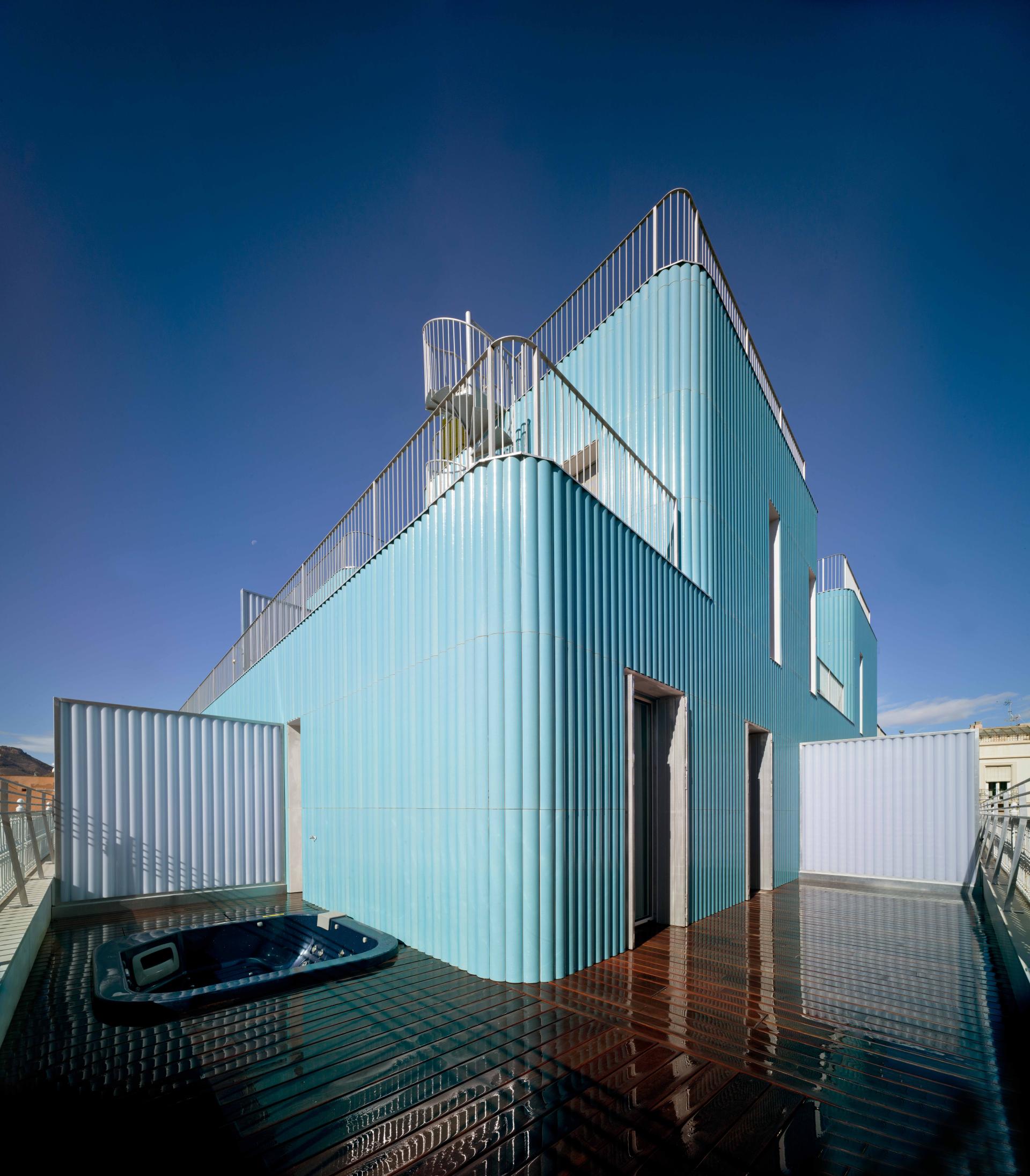 Innovative blue ceramic façade of a contemporary building, showcasing Spanish design excellence in architecture and interior style.