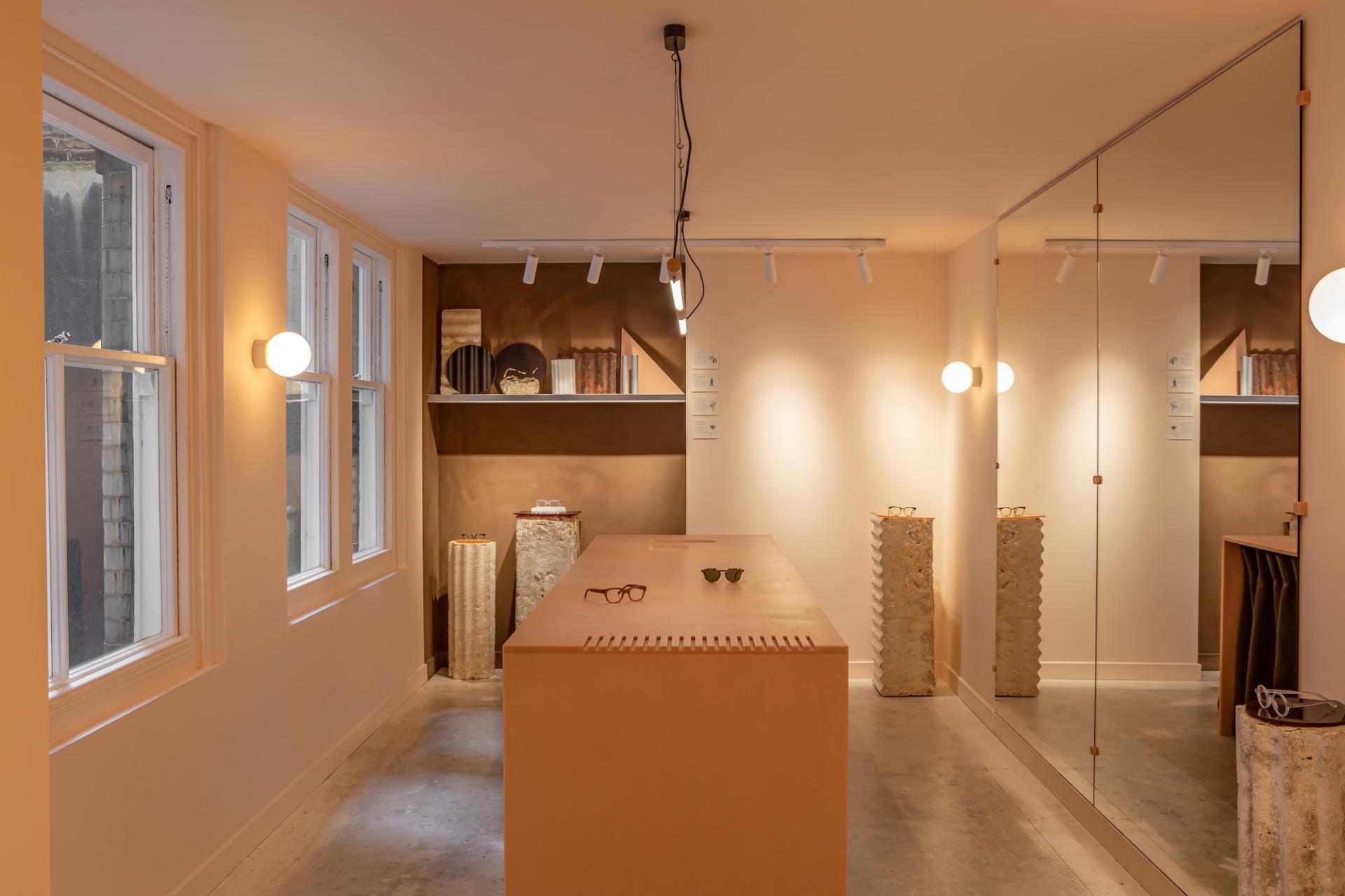 Stylish eyewear displayed on a minimalist counter inside a modern, eco-friendly store.