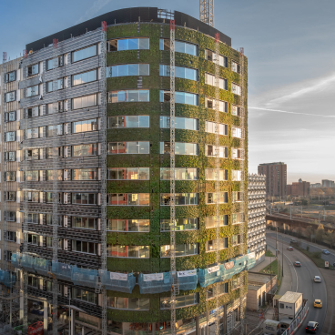 Sustainable architecture featuring a green façade on a modern building in Manchester's urban landscape, enhancing biodiversity.